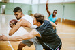 © Marko Geber - Diverse group of young men playing basketball in an indoor basketball gym