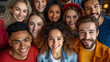 © Jorgarsan - A close-knit group of happy young people from various ethnic backgrounds are posing together indoors for a cheerful group selfie