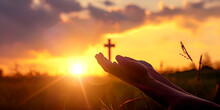 As The Sun Descends, Let Your Prayers Ascend, Bridging The Earthly And The Divine." | Person Praying In The Sunset Holding Cross Christian Religion Concept Background