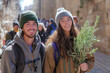 Believing faithful in the celebration of Palm Sunday in Holy Week, Young couple carrying branches and touring Christian villages