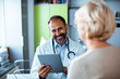 © Davor - Smiling doctor talking to a female senior patient with good news in his office in a hospital or clinic
