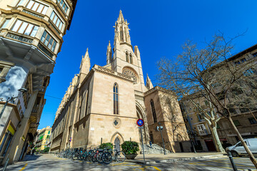 Wall Mural - Catholic church under blue sky on the street of Palma, Spain.