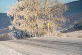 Fototapeta Maki - Mountain road on an extremely cold morning, surface covered with ice and snow.