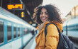 Smiling woman with backpack waiting train at train station. Copy space for text. Travel, backpacker concept.