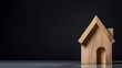 Miniature wooden house on the black background.  investment, property, real estate theme