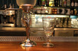 Absinth fountain and glass with spoon on bar counter close-up.