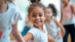 Smiling young girl in dance class with peers, enjoying choreography lesson.