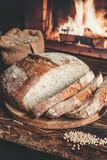 Fototapeta Na sufit - Homemade bread on the background of a home hearth