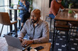 © ReeldealHD images - African American male freelancer working from a cafe