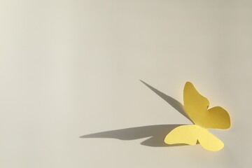 Poster - Yellow paper butterfly on light grey background, top view. Space for text