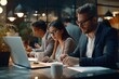 © Fotograf - A group of individuals sitting at a table, each working on their own laptop. Suitable for business, teamwork, and technology concepts