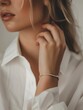 © mariiaplo - Close-up of a woman's elegant bracelet as she touches her neck