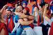 © Drazen - Excited couple of fans embracing after their favorite team's championship victory at stadium.