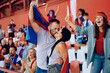 © Drazen - Couple of sports fans kissing while celebrating during match at stadium.