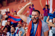 © Drazen - Passionate sports fan shouting during match at stadium.