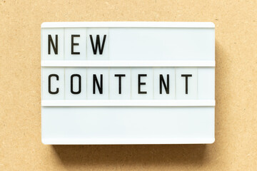 Poster - Lightbox with word new content on wood background