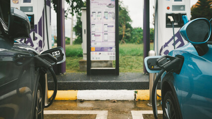 Wall Mural - Electric car charging at electric vehicle charging station. Battery to electric car, Green renewable energy battery storage future. 