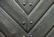 Old wooden door with rivets and nails, close-up photo in the old town.