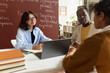 © Mediaphotos - Portrait of smiling female teacher of student advisor talking to girl and parent during meeting in class