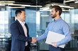 © Liubomir - Professional and friendly handshake between two businessmen in an office setting, symbolizing partnership, agreement, and teamwork.