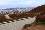 Fototapeta  - San Francisco, California: skyline from Twin Peaks and curved road Twin Peaks Blvd