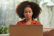 © DragonImages - Portrait of woman watching educational video on laptop at home