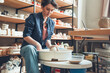 © Irina - A woman in a pottery workshop works on a potter's wheel. Pottery craft, shaping a clay product, weekend activity