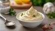 A Close-Up of Delicious Mayonnaise in a Bowl with a Spoon, Set on a Kitchen Table
