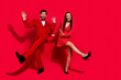Leinwandbild Motiv Full body photo of pretty lady handsome man have fun dancing christmas event isolated on red color background