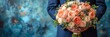 Groom holding stunning wedding bouquet with vibrant flowers against blue backdrop in studio.