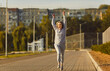 © Studio Romantic - Positive senior woman running and jogging with a smile in a city park. This dynamic scene captures the blend of happiness and sport, showcasing the woman enthusiasm for an active lifestyle.