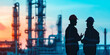 © Gabriela - Silhouette of two workers talking, with blurred factory background