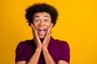 Photo of positive overjoyed guy open mouth two arms touch cheeks rejoice success win lottery jackpot isolated on yellow color background