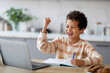 © Prostock-studio - Little Black Schoolboy Using Laptop And Celebrating Success At Home