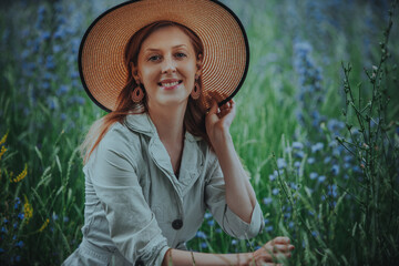 Wall Mural - Portrait of beautiful smiling woman wearing hat in summer field