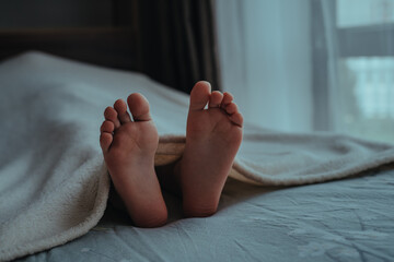 Wall Mural - Feet of sleeping baby on the bed