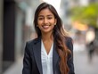 © Athena - Attractive young Indian business woman smiles in the street out while out at lunch