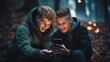 Close-up of two smiling young teenage boys looking at a smartphone together, exchanging phone numbers in the evening in the park.