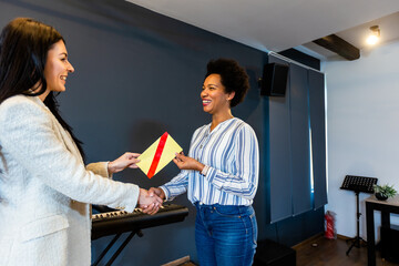 businesswoman receiving award in front of business professionals, applauding at business seminar in 
