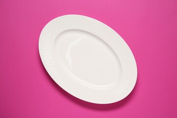 Canvas Print - One white plate on pink background, top view