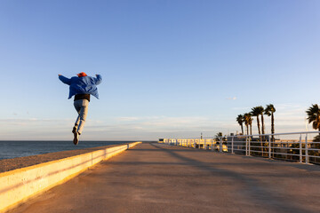 woman dancing in a port at sunset, red hair, smiling