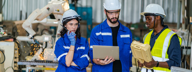 Professional electrical engineer in safety uniform working in control room at factory site. Industrial technician worker checking maintenance electric system by using laptop computer at industry plant