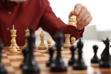 Wall Mural - Man playing chess at table indoors, closeup