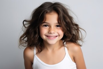 Portrait of a cute little girl with long hair over grey background