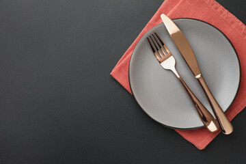 Clean plate, cutlery and napkin on grey table, top view. Space for text