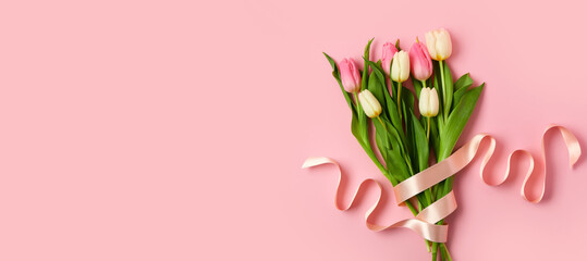Beautiful tulips with ribbon on pink background with space for text. International Women's Day
