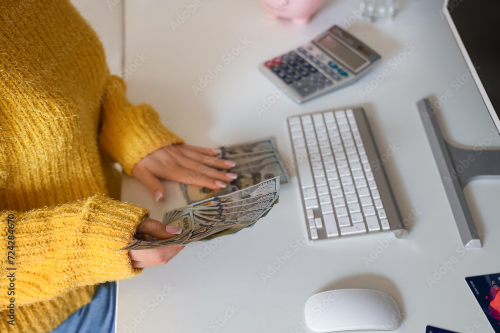 Young woman counting money at home, closeup
