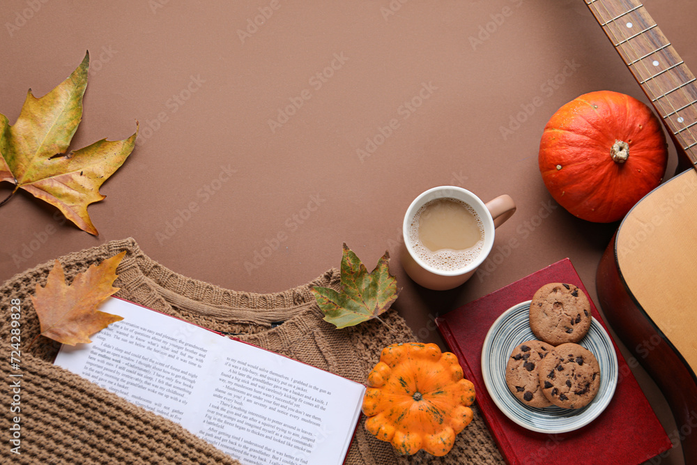 Composition with cup of coffee, book and autumn decor on color background