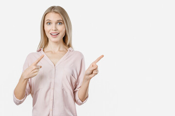 Portrait of surprised pretty young woman pointing with two fingers. Copy space free empty space place. Advertisement concept