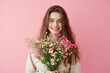 © Melanthe - Beautiful happy young woman with bouquet of spring flowers on pastel pink background. Romantic studio portrait. Springtime, Mothers day, Valentines day concept. Design for posters, banner